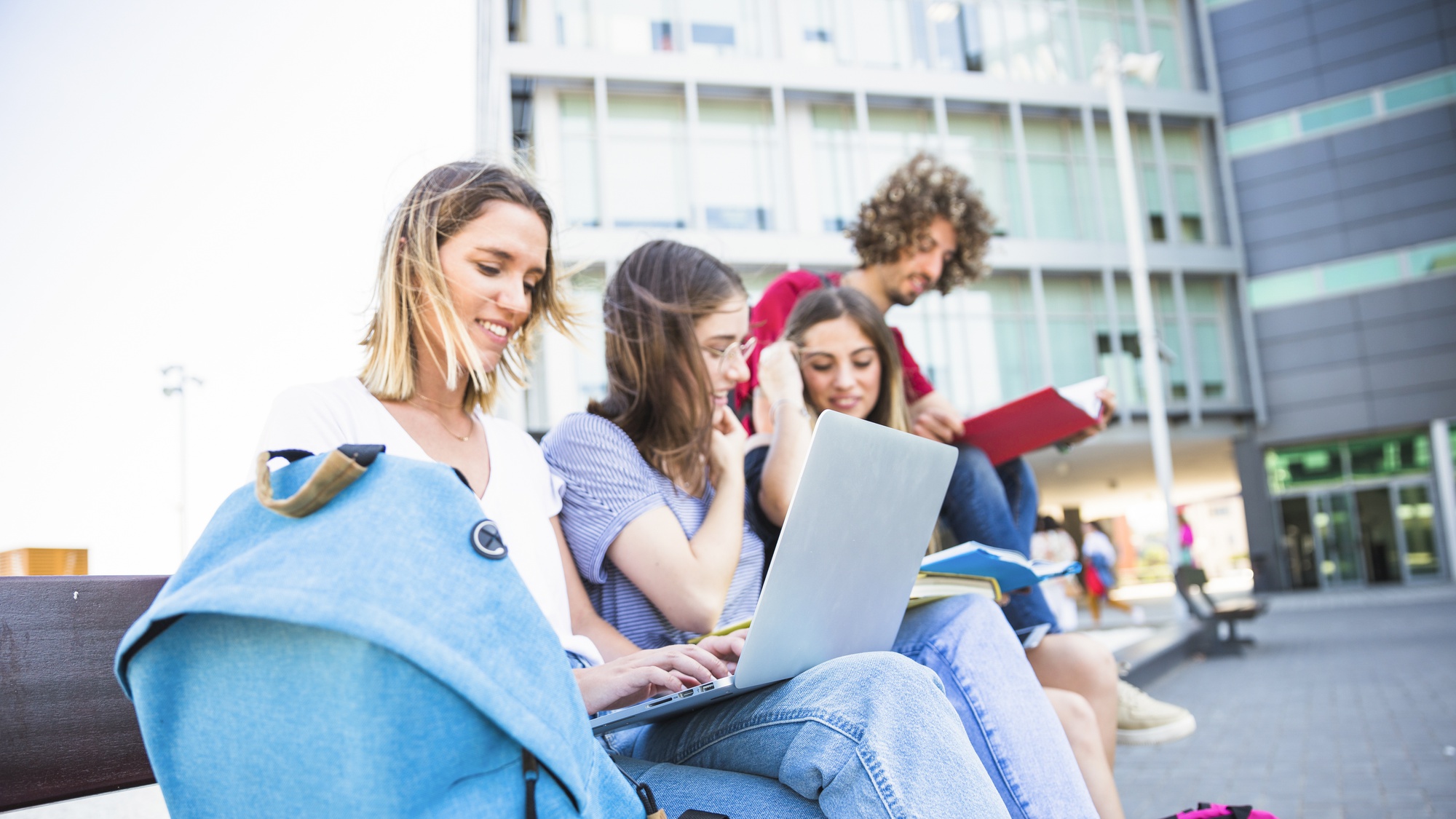 female-using-laptop-near-studying-friends.jpg